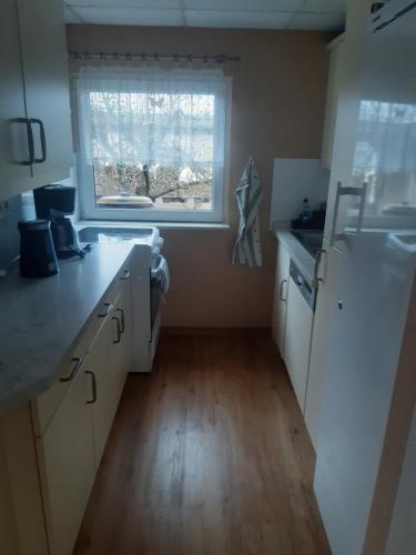 a kitchen with a white refrigerator and a window at Bed and Breakfast Korswandt 1 in Korswandt