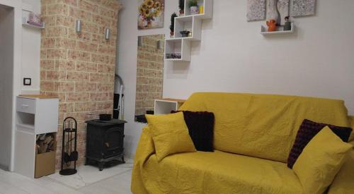 a yellow couch in a living room with a fireplace at Frendly Flat Free Parking Kitchen Equipment Cosy in Rīga