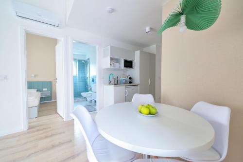 a white dining room with a white table and chairs at Villa Oliver 2 Hévíz in Hévíz