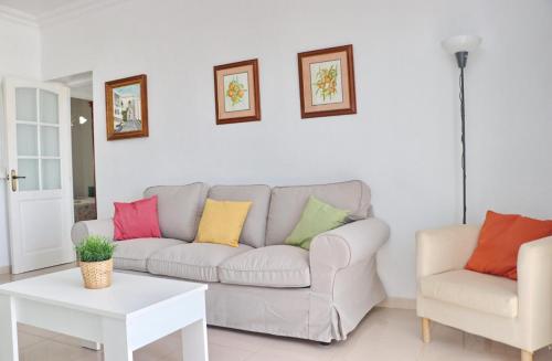 sala de estar con sofá y almohadas coloridas en Apartamento La Fuente, en Conil de la Frontera