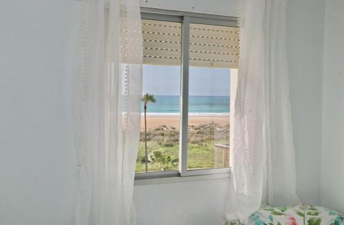 コニル・デ・ラ・フロンテーラにあるApartamento La Fuenteのビーチの景色を望む窓付きのベッドルーム1室