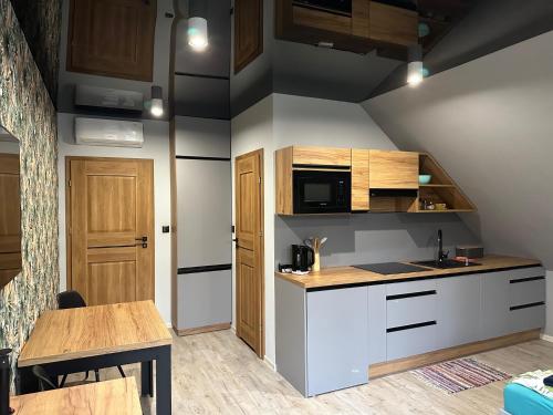 małą kuchnię ze stołem i kuchenką mikrofalową w obiekcie Apartament nad Jeziorem w mieście Skorochow
