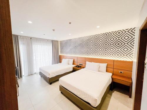 a hotel room with two beds and a wall mural at The Manaoag Hotel in Manaoag
