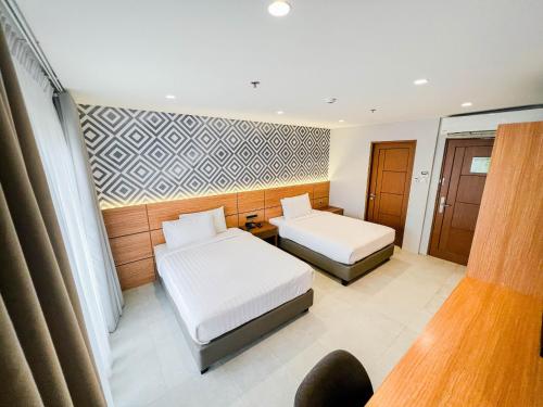 a hotel room with two beds and a window at The Manaoag Hotel in Manaoag