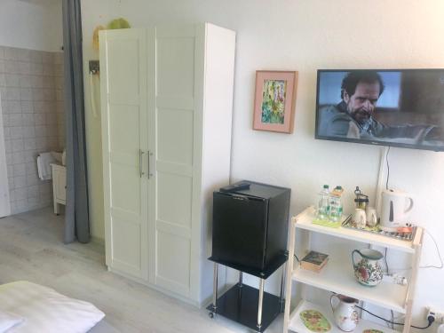 a room with a television on a wall with a shelf at Haus am Kurpark in Schömberg