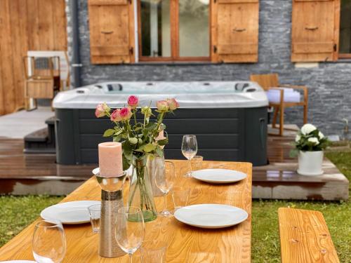 a table with glasses and a vase of flowers on it at Les Trois Pointes in Morzine