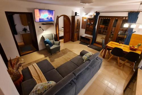 a living room with a couch and a dining room at Égig Érő Fa Vendégház in Nógrád