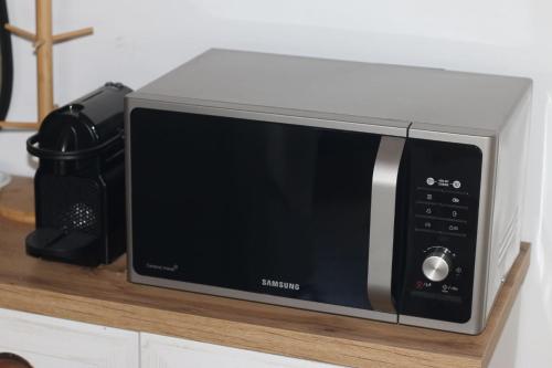 a microwave oven sitting on a wooden shelf at Asteri Apartments Mytikas 2-Bedroom Penthouse 360 Views in Mýtikas