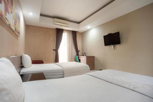 Ένα ή περισσότερα κρεβάτια σε δωμάτιο στο Safwah Bintaro Syariah Mitra RedDoorz