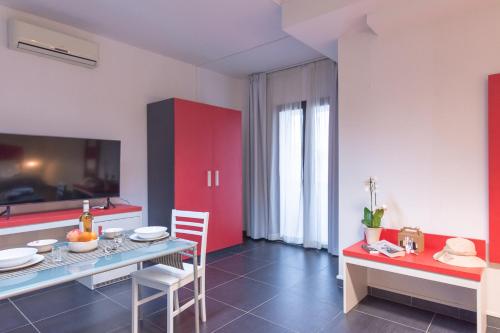 a kitchen with red cabinets and a table and chairs at Delta Rooms in Olbia