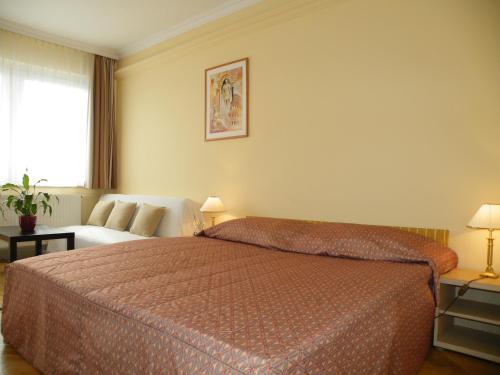 ブダペストにあるアパートメント ブダ ブダペストのベッドとソファ付きのホテルルーム