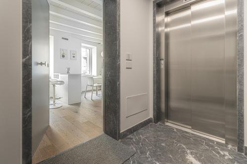 a hallway with a glass door and a table at Porta Palio Luxury Apartment in Verona