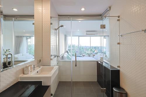 a bathroom with a sink and a glass shower at Sunset Residence Karon Beach in Karon Beach
