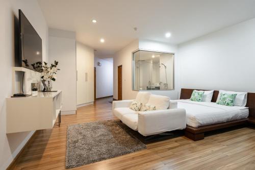 a living room with a white bed and a couch at Sunset Residence Karon Beach in Karon Beach