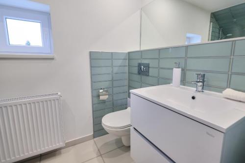 a bathroom with a white sink and a toilet at Villa Oliver 2 Hévíz in Hévíz