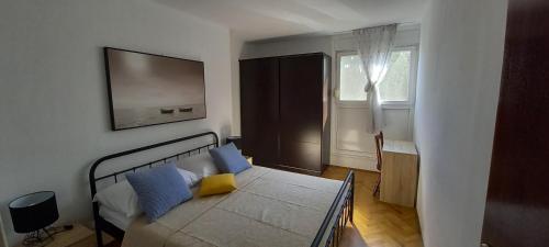 1 dormitorio con 1 cama con almohadas azules y amarillas en Frane, en Split