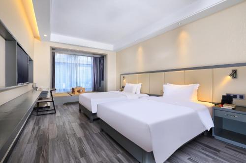 a hotel room with two beds and a flat screen tv at Wing Hotel Guilin - Central Square in Guilin