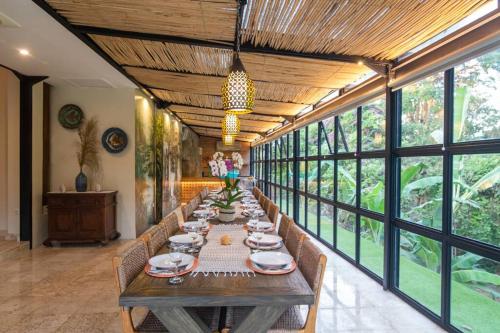 een lange eetkamer met een lange tafel en stoelen bij Sunset Paradise Villa Nusa Dua in Nusa Dua