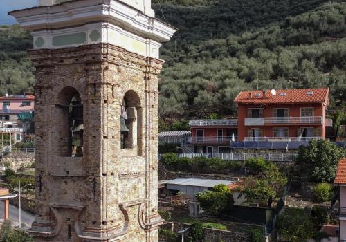 an old clock tower in a city with buildings at Agriturismo La Rocca in San Bartolomeo al Mare