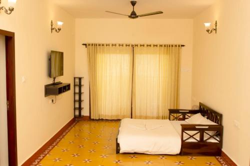 a bedroom with a bed and a flat screen tv at The Royale Ridge in Kotagiri