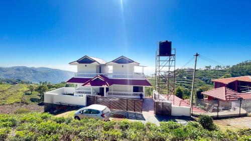 a white house with a car parked in front of it at The Royale Ridge in Kotagiri