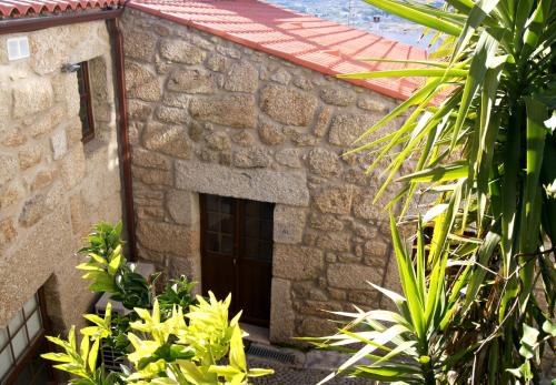 um edifício de pedra com uma porta e algumas plantas em Cantinho Santiago em Belmonte