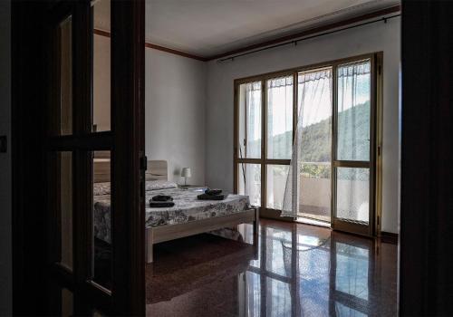 Cette chambre comprend un lit et une grande fenêtre. dans l'établissement Agriturismo La Rocca, à San Bartolomeo al Mare