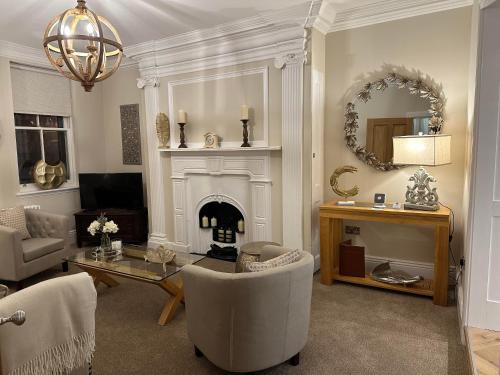 a living room with a fireplace and a table and chairs at Strother's Townhouse in Berwick-Upon-Tweed