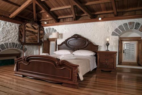 1 dormitorio con 1 cama grande y suelo de madera en Mansion Eugenie en Hydra