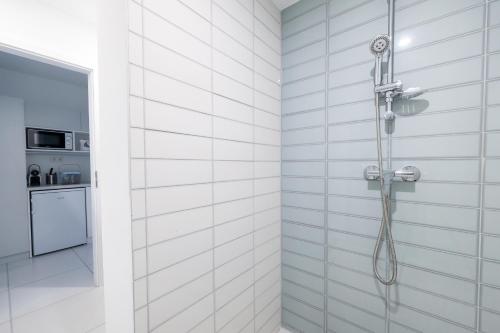 a shower in a white tiled bathroom at Villa Oliver 2 Hévíz in Hévíz