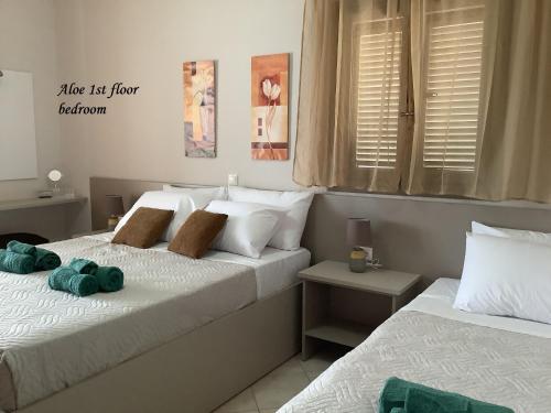 ein Schlafzimmer mit 2 Betten und Handtüchern darauf in der Unterkunft Arokaria Holiday Houses in Platanes
