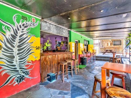 un restaurant avec des murs colorés, des tables et des chaises dans l'établissement Tekweni, à Durban