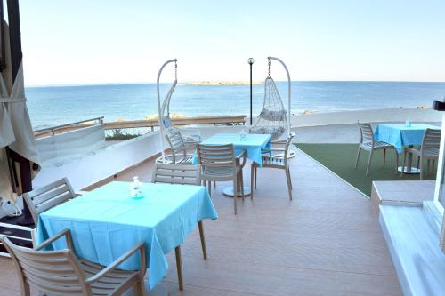 a patio with tables and chairs and the ocean at Klinakis Beach Hotel in Chania Town