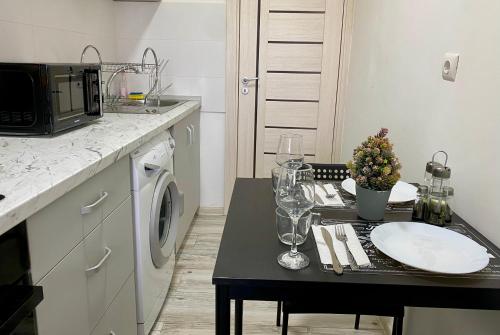 a small kitchen with a table with a microwave at Garsoniera 2 Mega Mall in Bucharest