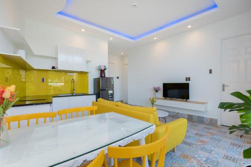 a kitchen with yellow cabinets and a table and chairs at Sea House Hotels and Apartments in Vung Tau