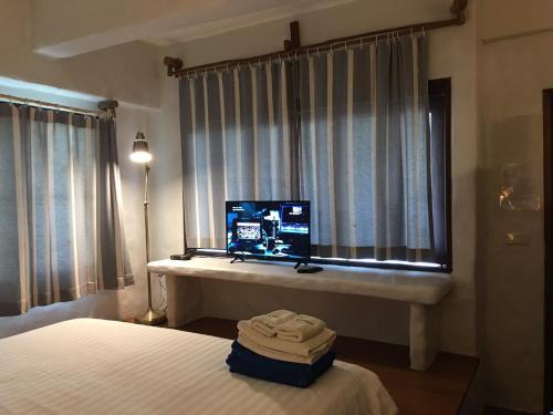 a bedroom with a bed and a television in a window at Koh Mak Cococape Resort in Ko Mak