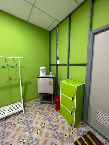 a green room with a sink and a table in it at Baan Tarn Naam in Ban Lam Ru (1)