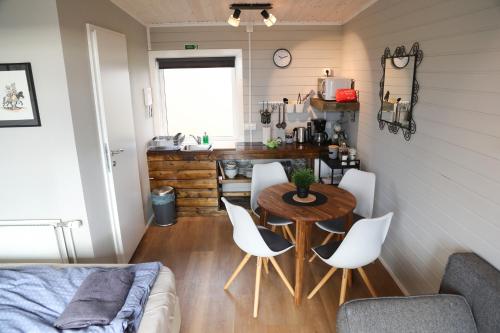 a small dining room with a table and white chairs at Áshamrar in Hella