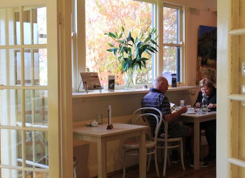 dos personas sentadas en una mesa en un restaurante en Dunkeld Old Bakery Accommodations, en Dunkeld