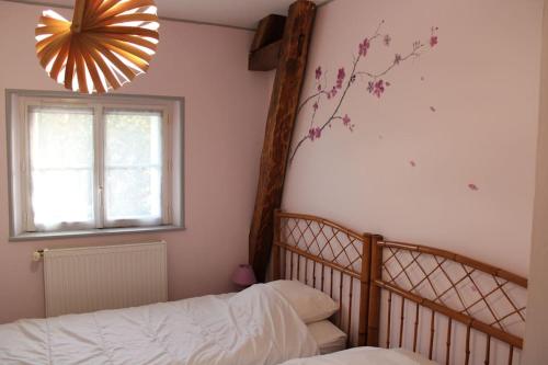 - une chambre avec un lit, une fenêtre et un lustre dans l'établissement Gîte Natur'Amis, à Rivarennes