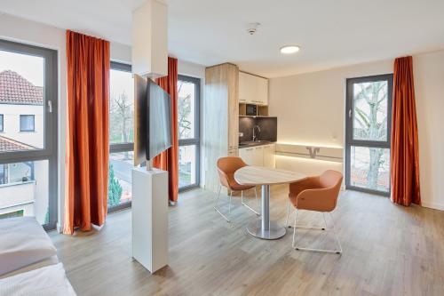 a room with a table and chairs and a kitchen at VR-Serviced Apartments Gerstungen in Gerstungen