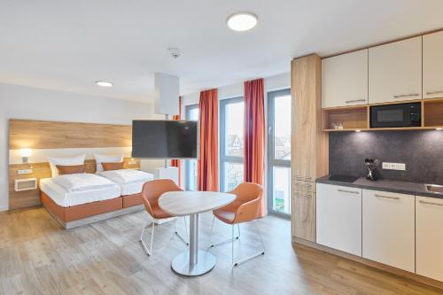 um quarto de hotel com uma cama, uma mesa e cadeiras em VR-Serviced Apartments Gerstungen em Gerstungen