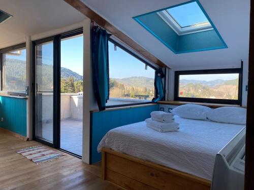 een slaapkamer met een bed en uitzicht op de bergen bij La maison de gravies in Anduze