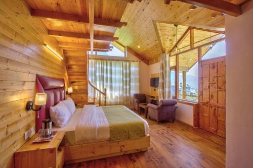 a bedroom with a bed in a room with wooden walls at Chichoga Heights in Manāli