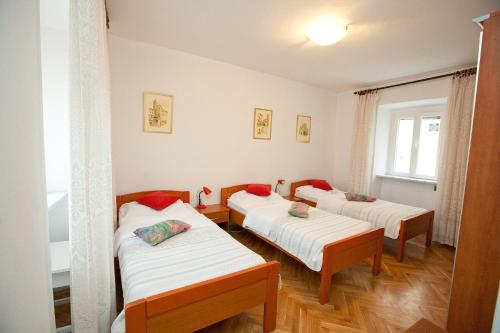 a room with three beds and a window at Victoria Spire Center of the Old Town in Zadar