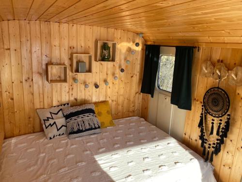 um quarto com uma cama num chalé de madeira em Maringotka Za humny em Rančířov