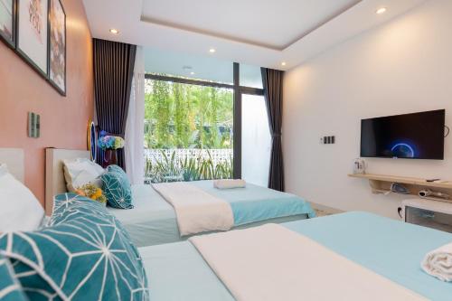 a hotel room with two beds and a television at Sea House Hotels and Apartments in Vung Tau