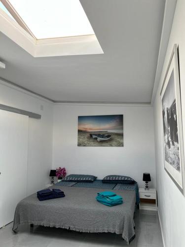 a white bedroom with a bed and a skylight at Manuda Luxury Apartment in Caleta De Fuste