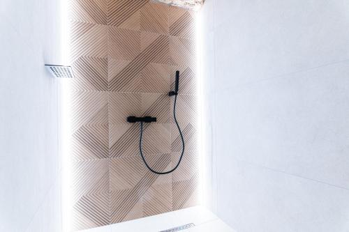 La salle de bains blanche est pourvue d'une douche avec un tuyau. dans l'établissement Legend Majestic SPA - Insolite & Unique - Champagne - Parking privé, à Bourg-en-Bresse