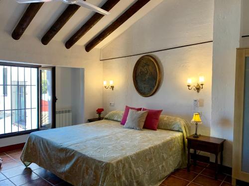 een slaapkamer met een groot bed met een klok aan de muur bij Los Palomos casa rural en el centro de Andalucía in Archidona